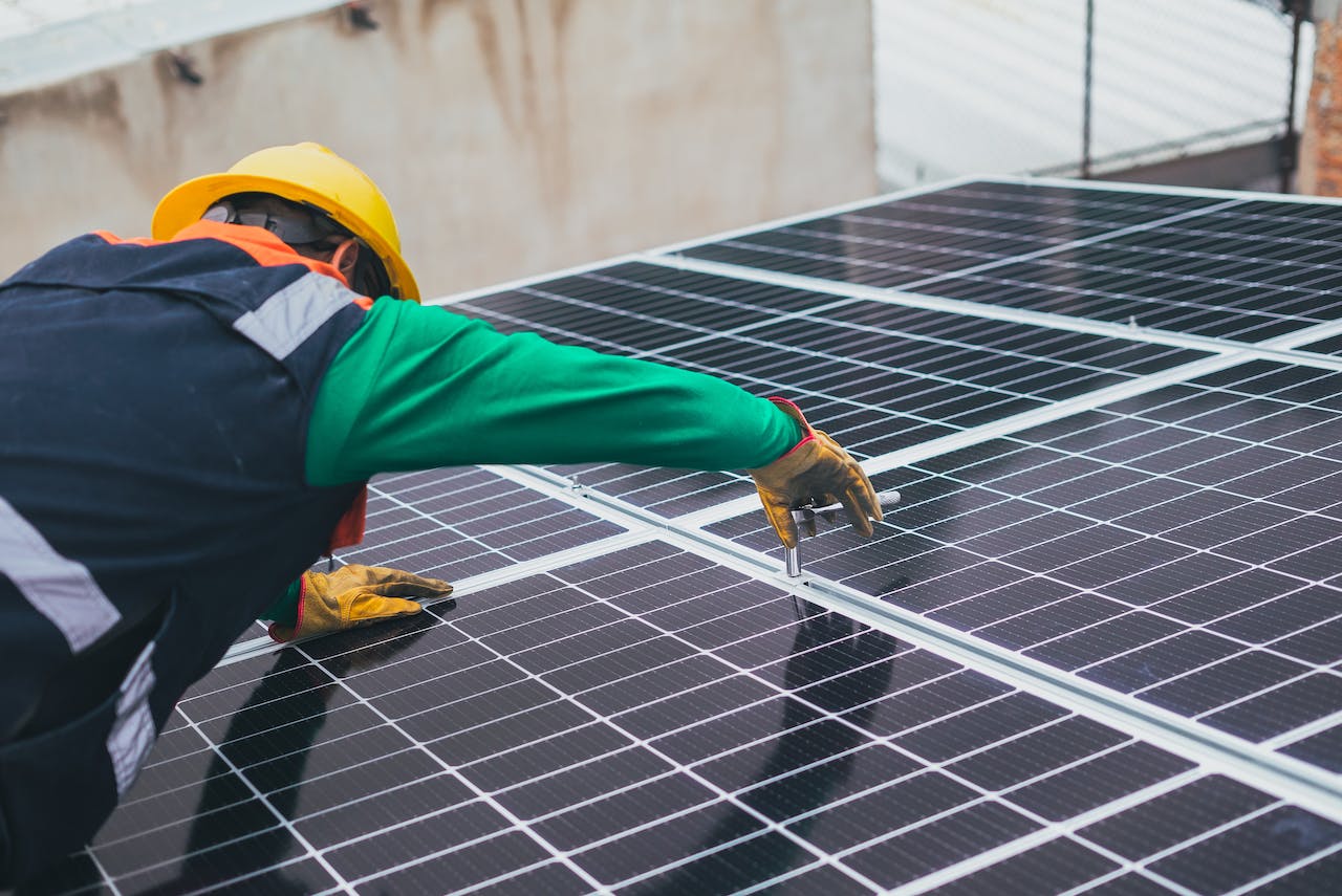a professional installing a solar panel so that the home could save money on electricity bills